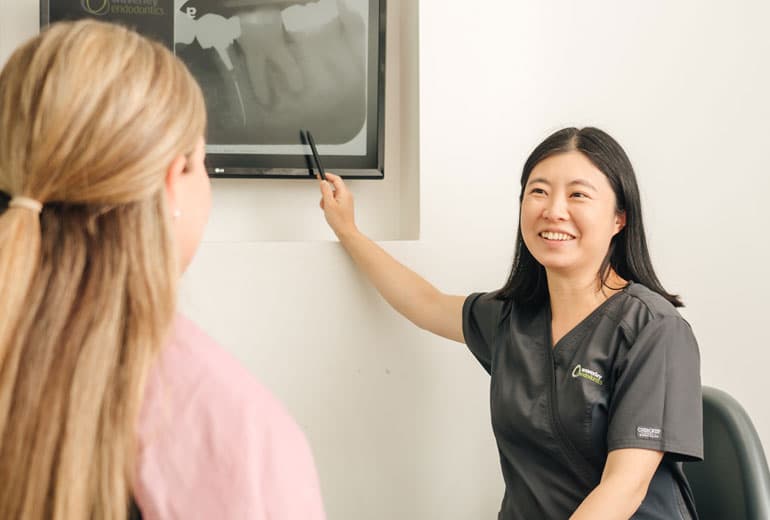 Endodontist explaining x-ray results to patient